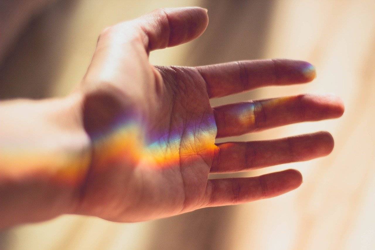 hand, with rainbow-coloured spectrum